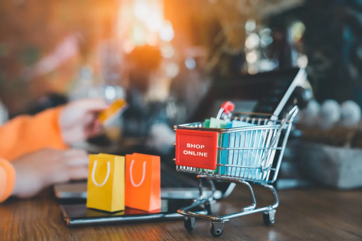 Online shopping cart with colorful bags and "Shop Online" text